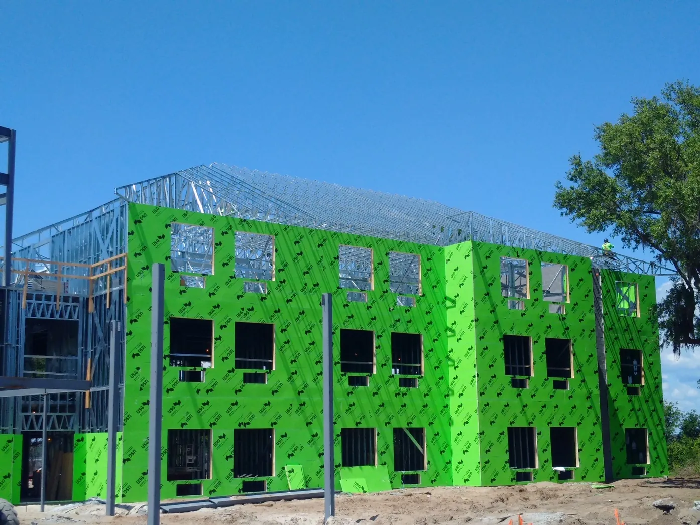 Three-storey cold-formed steel building with exterior sheathing and steel roof trusses